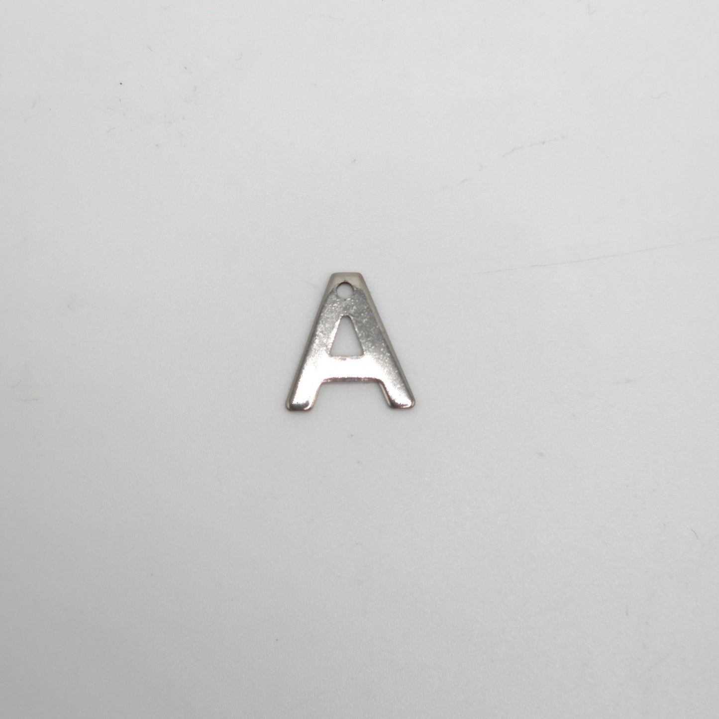 Silver letter 'A' charm on a light gray background