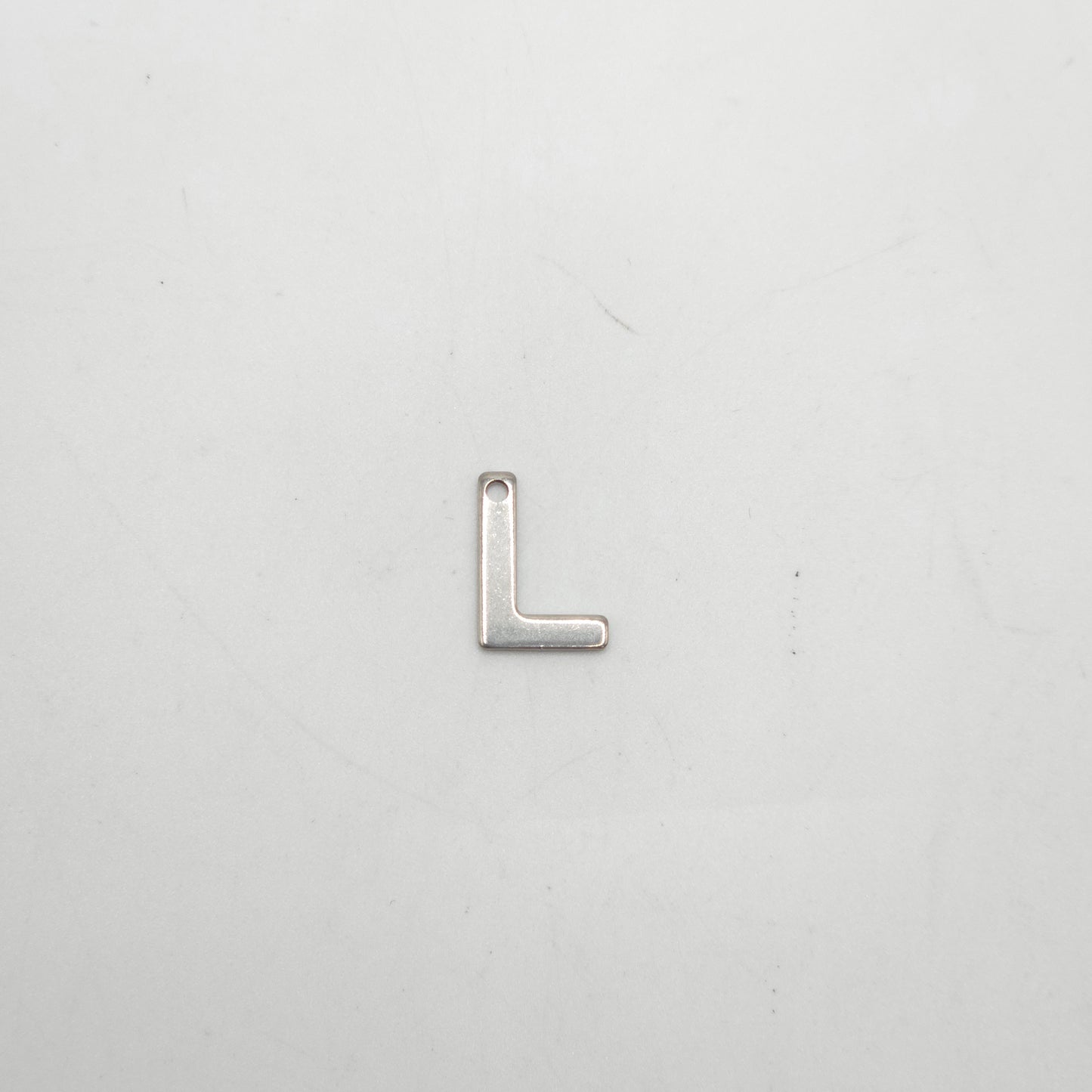 Silver letter 'L' charm on a white background