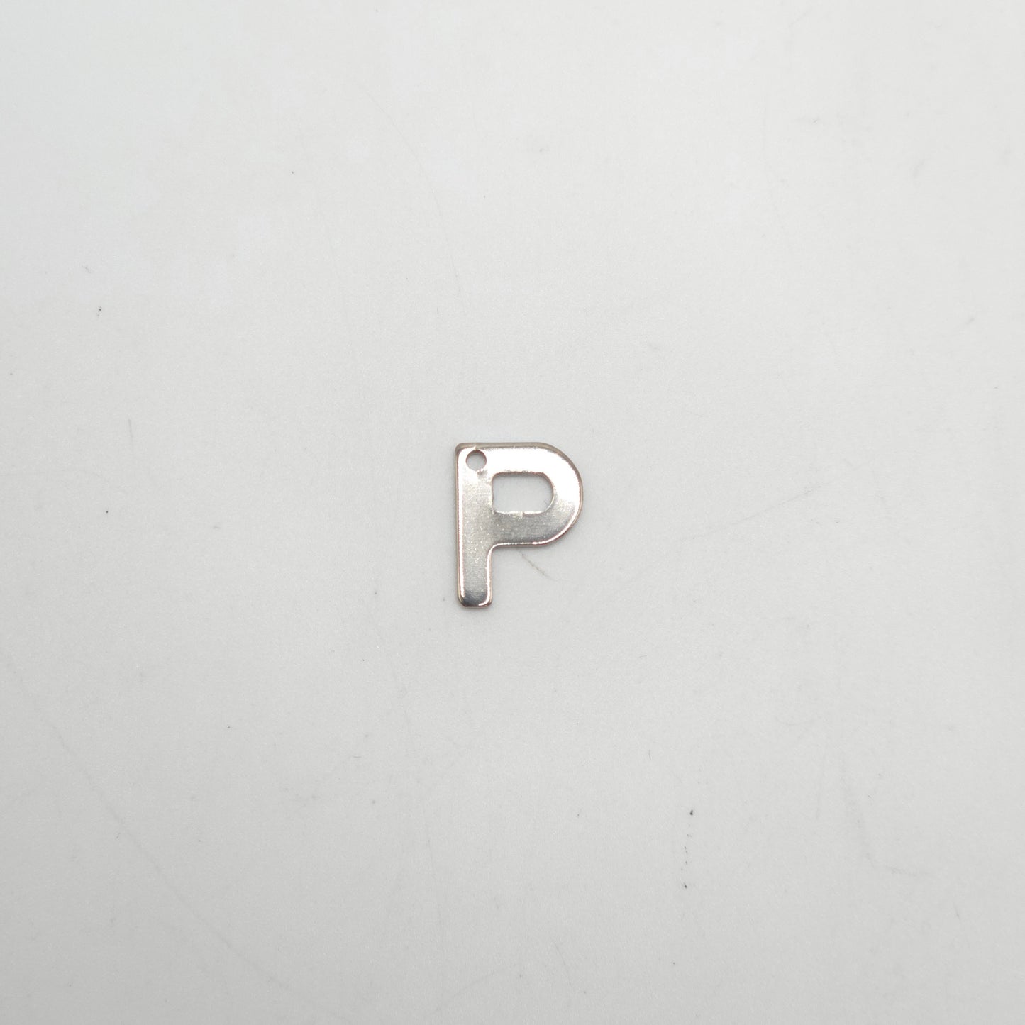 Silver letter 'P' charm on a light gray background