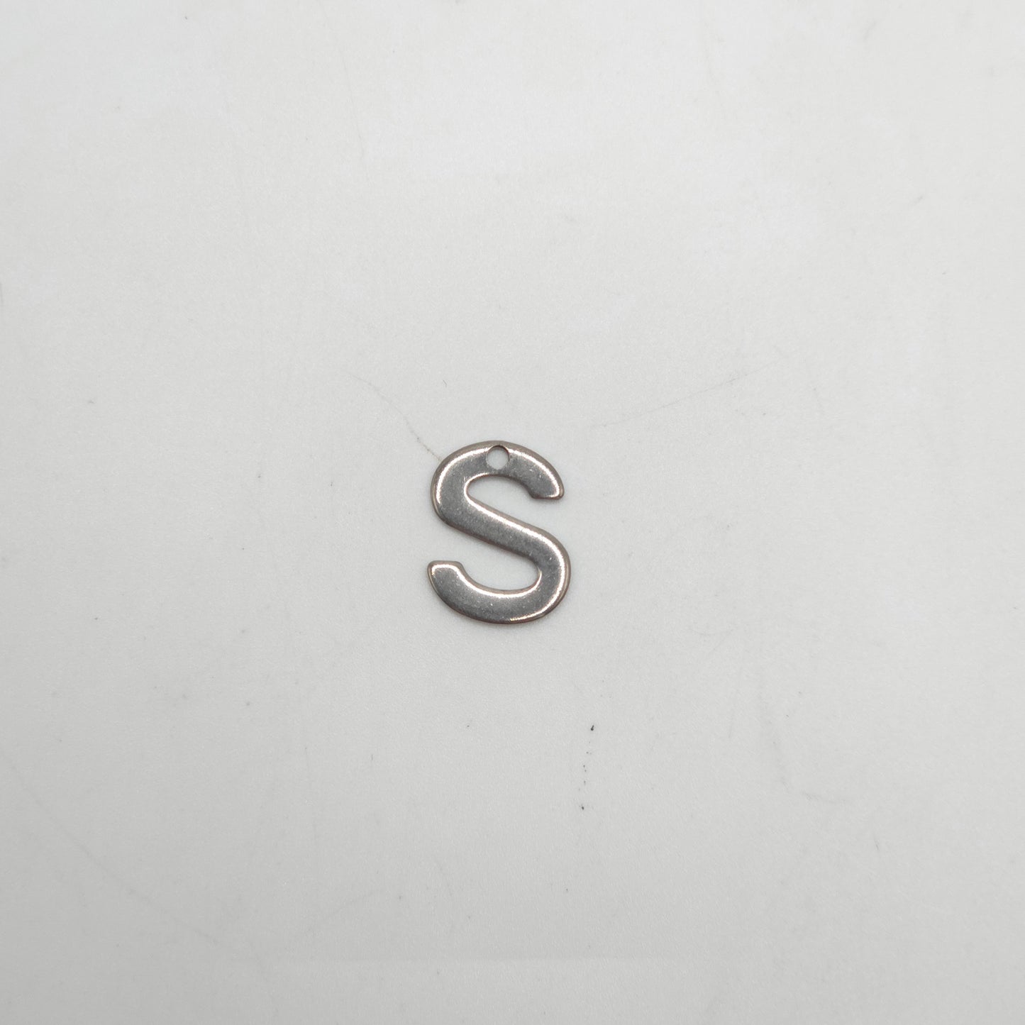 Silver letter 'S' charm on a white background