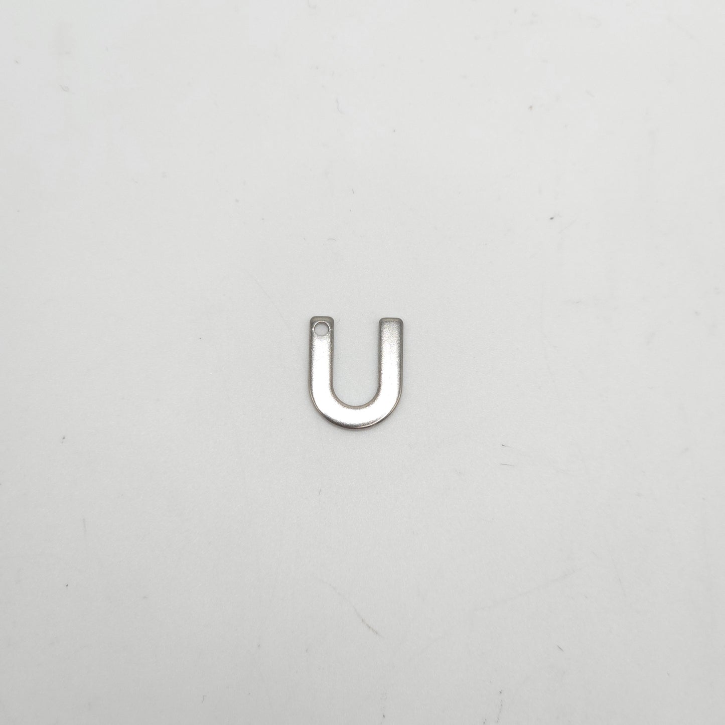 Silver U-shaped object on a light gray background