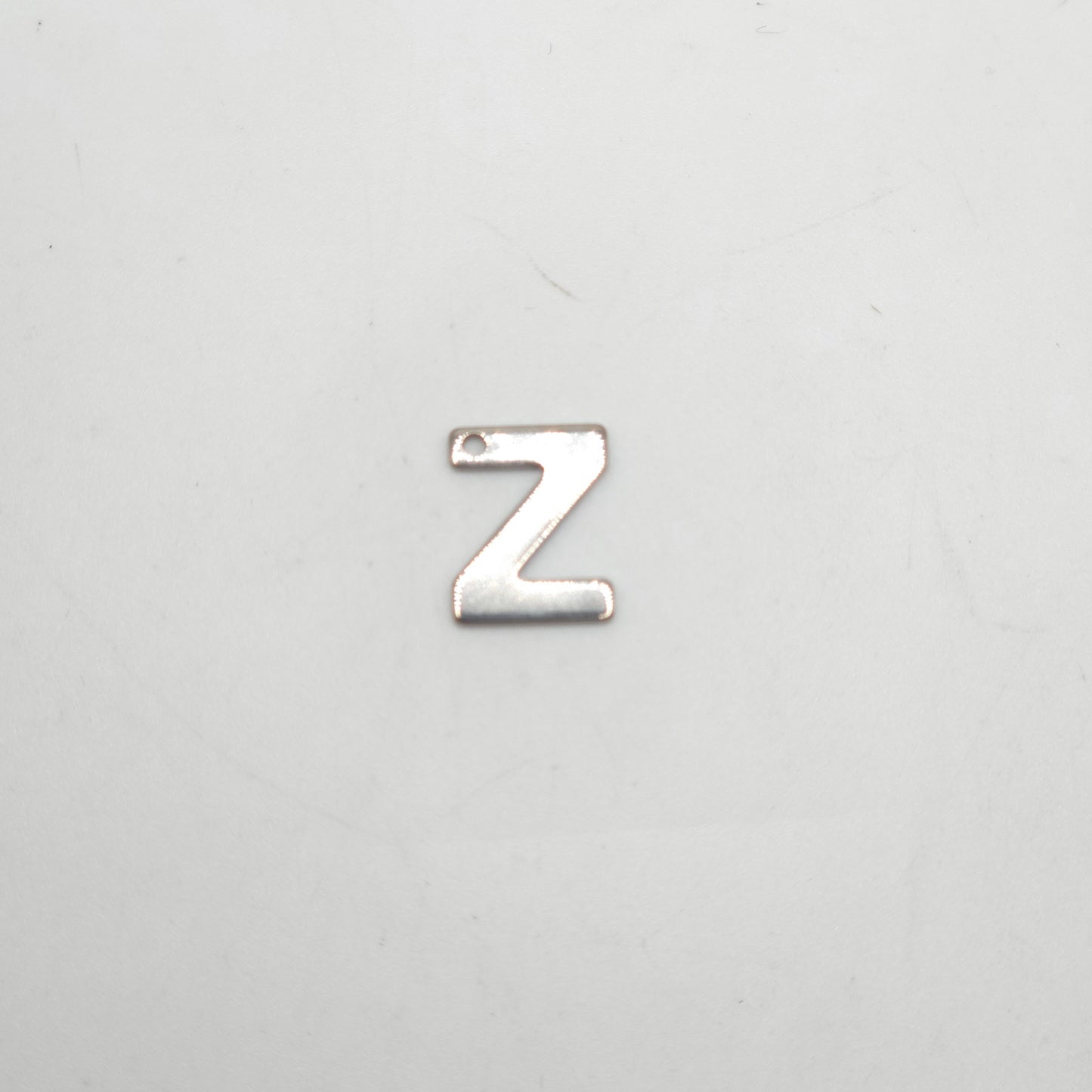 Silver letter 'Z' charm on a light gray background