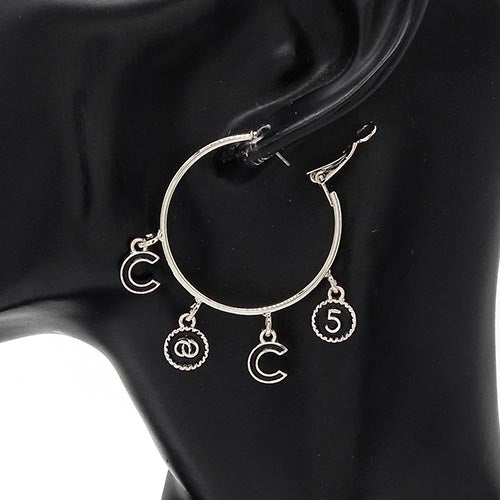 Silver hoop earrings with charms on a black background