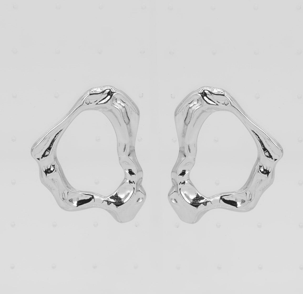 Pair of silver hoop earrings on a light gray background