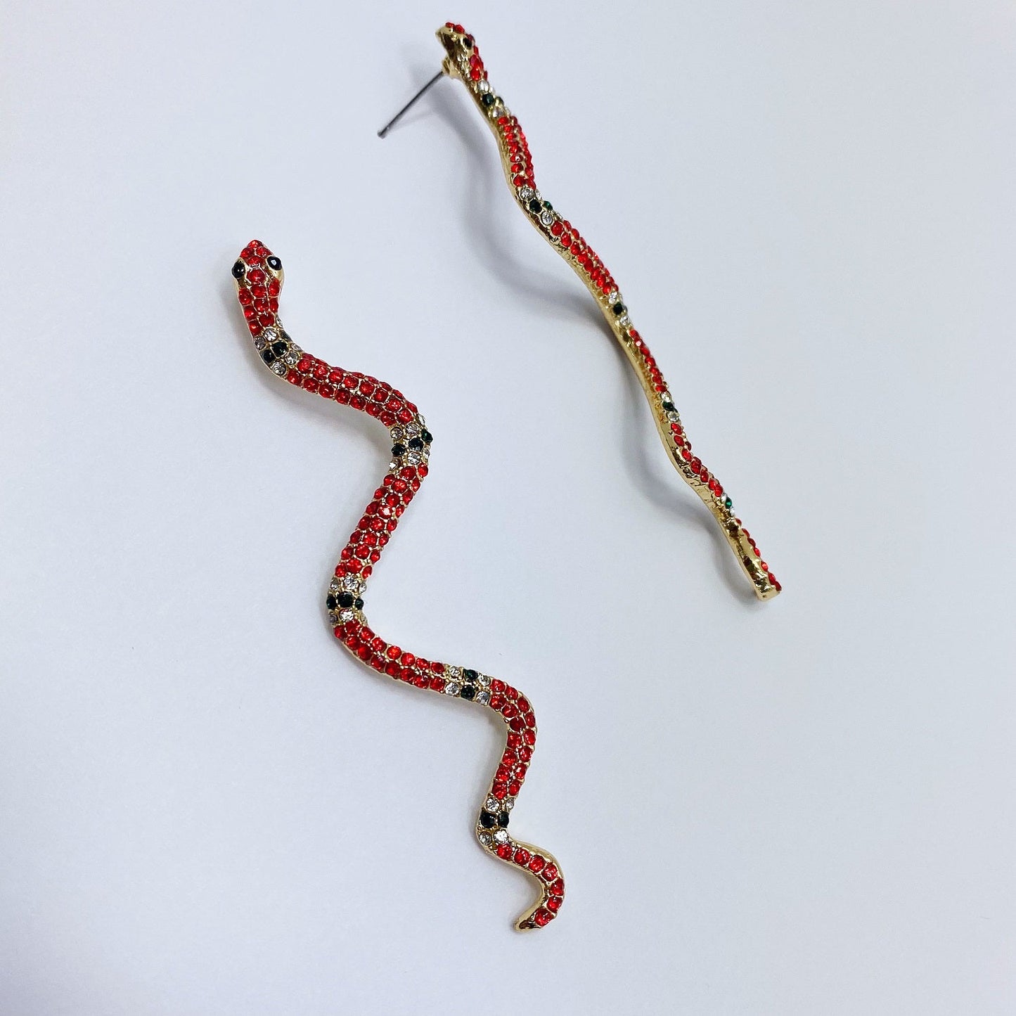 A pair of snake earrings on a white background