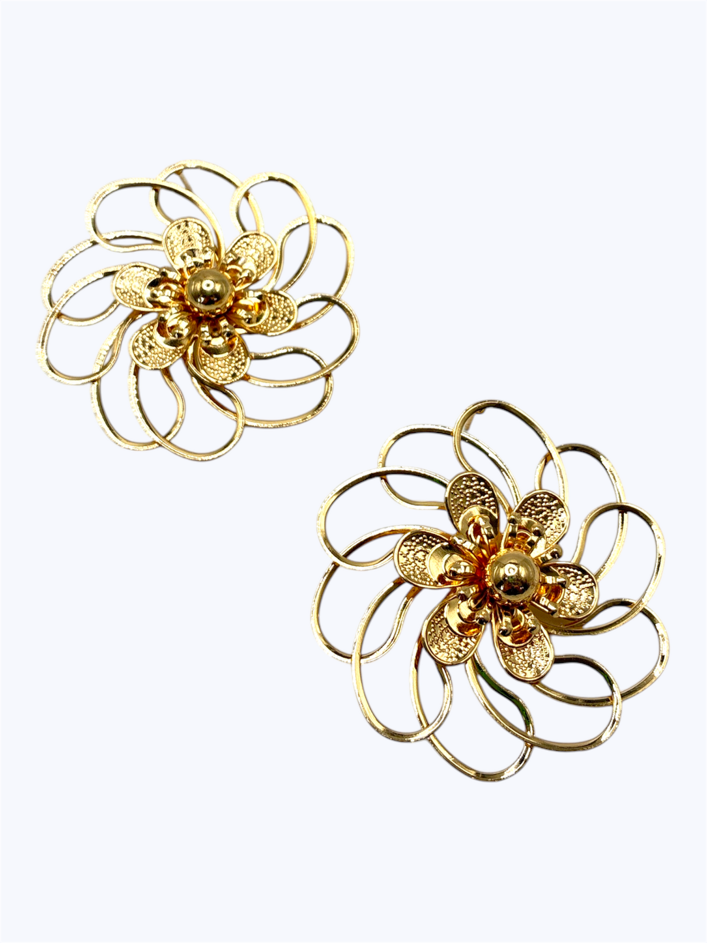 Layered floral stud earrings with open loop petals and intricate textured metal flower center design.