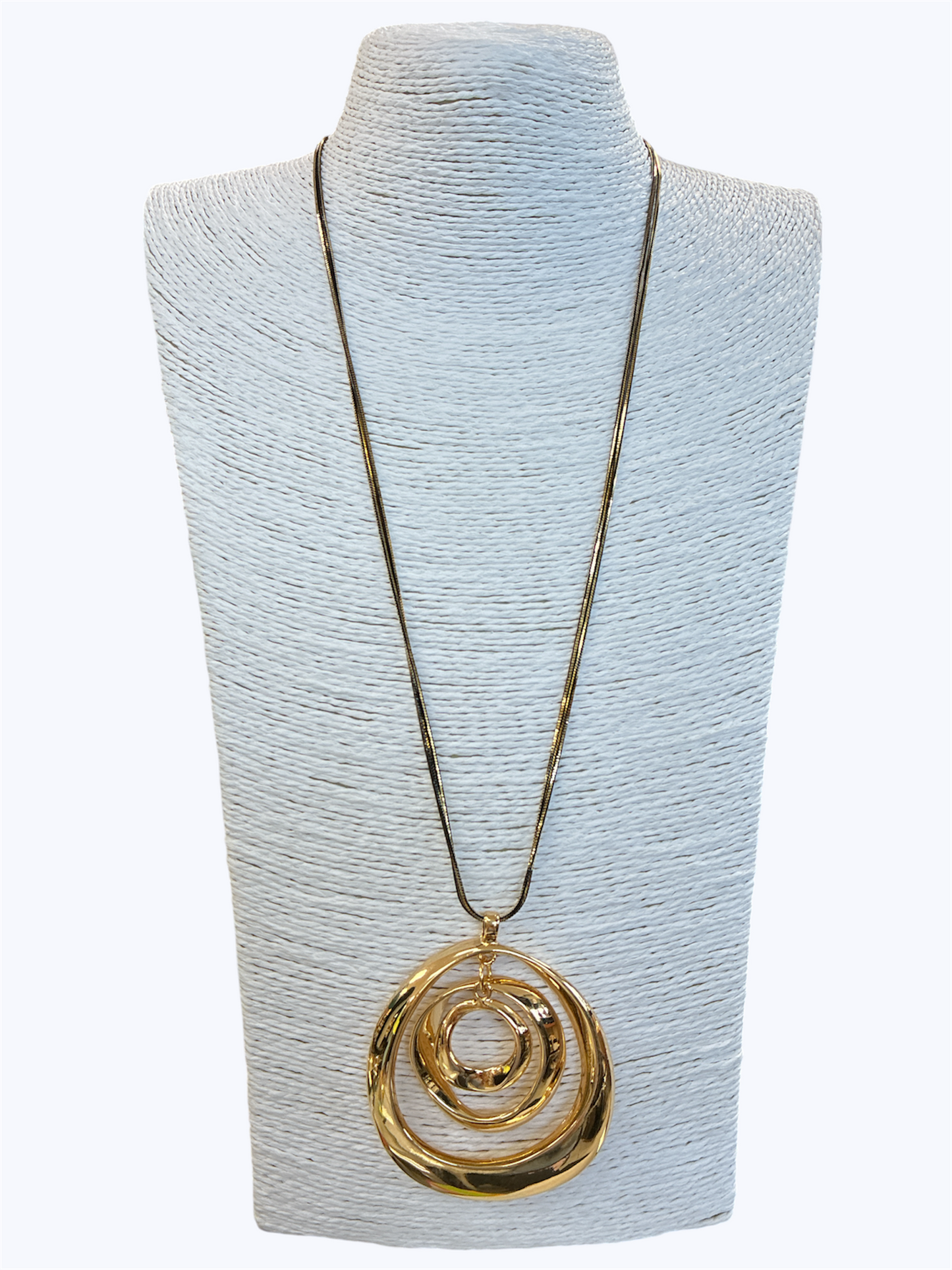 Gold necklace with a spiral pendant on a light blue mannequin bust.