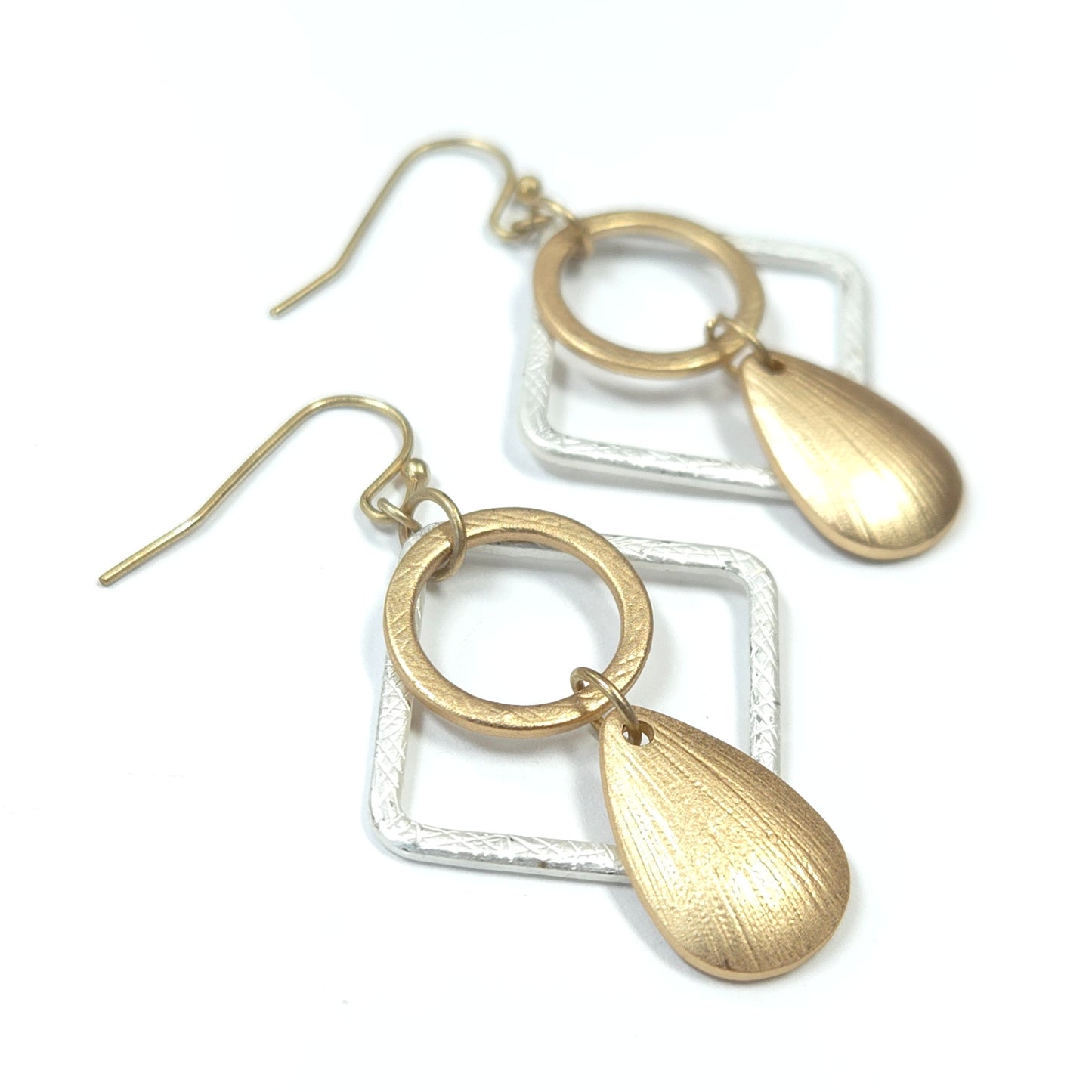Gold earrings with teardrop shapes on a white background
