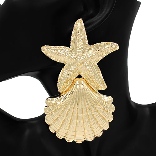 A pair of gold-colored earrings featuring a starfish on top of a shell design.