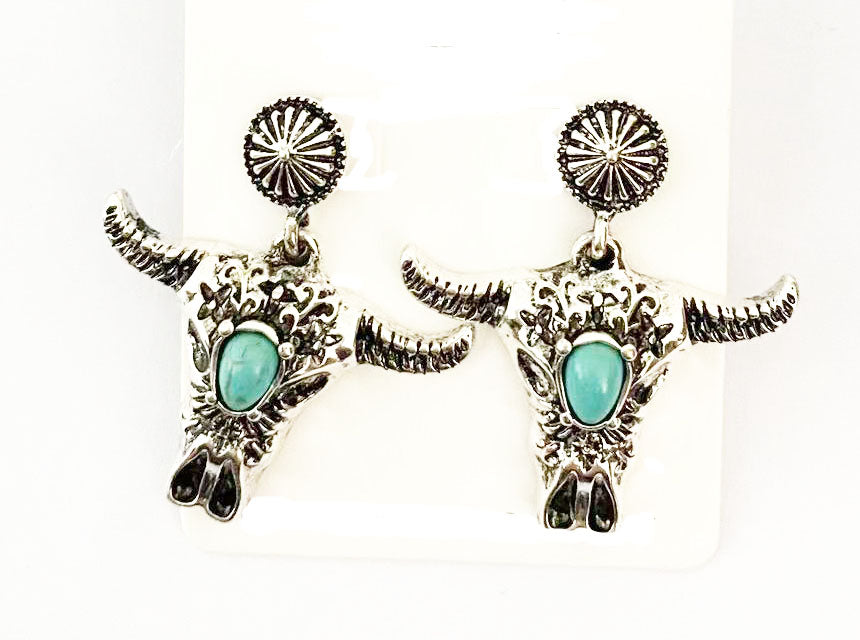 Silver bull head earrings with turquoise stones on a white background