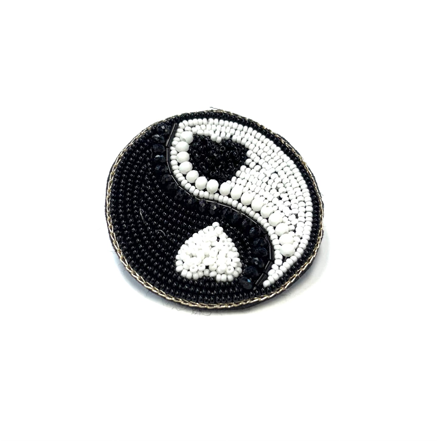 Beaded yin yang symbol on a white background