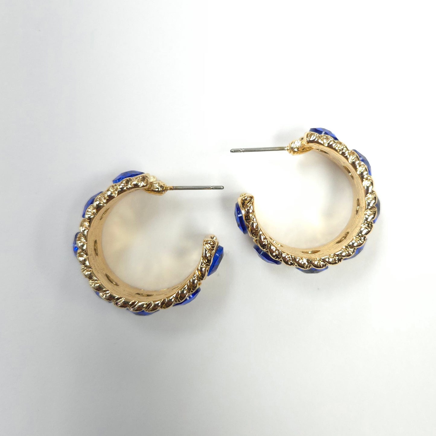 Gold hoop earrings with blue accents on a light gray background