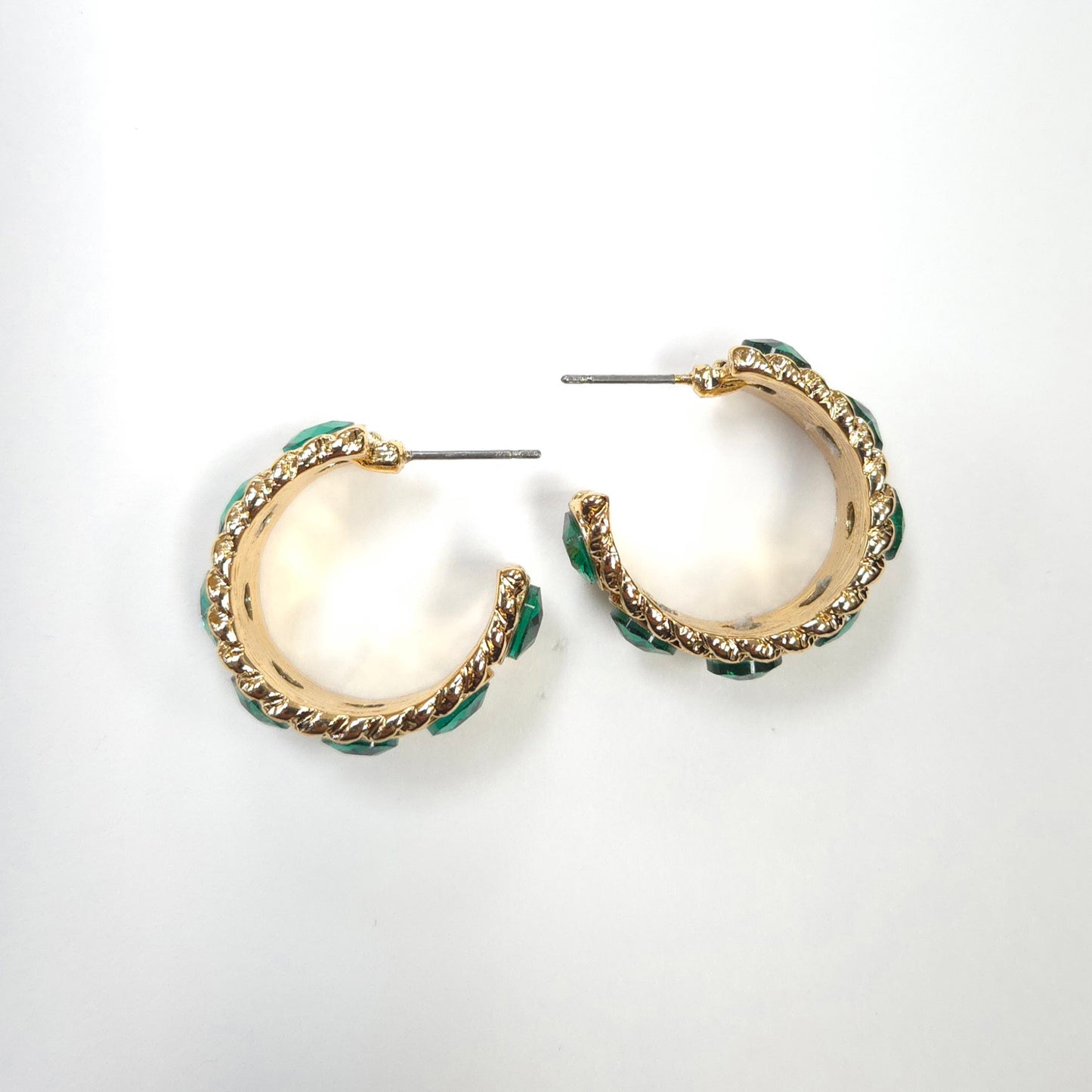 Gold hoop earrings with green accents on a white background