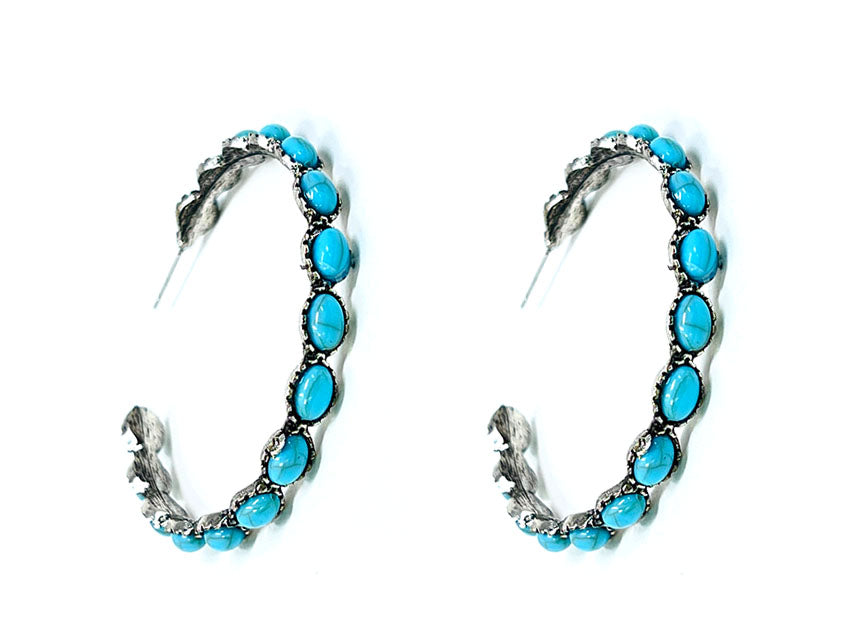 Pair of hoop earrings with turquoise stones on a white background