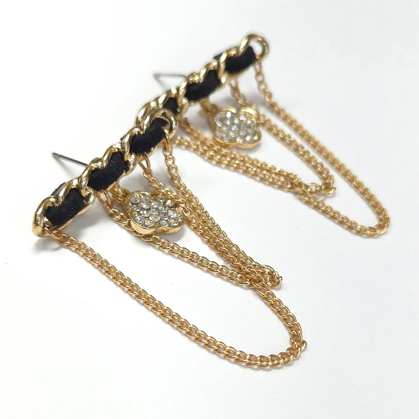 Gold chain earrings with black accents on a white background