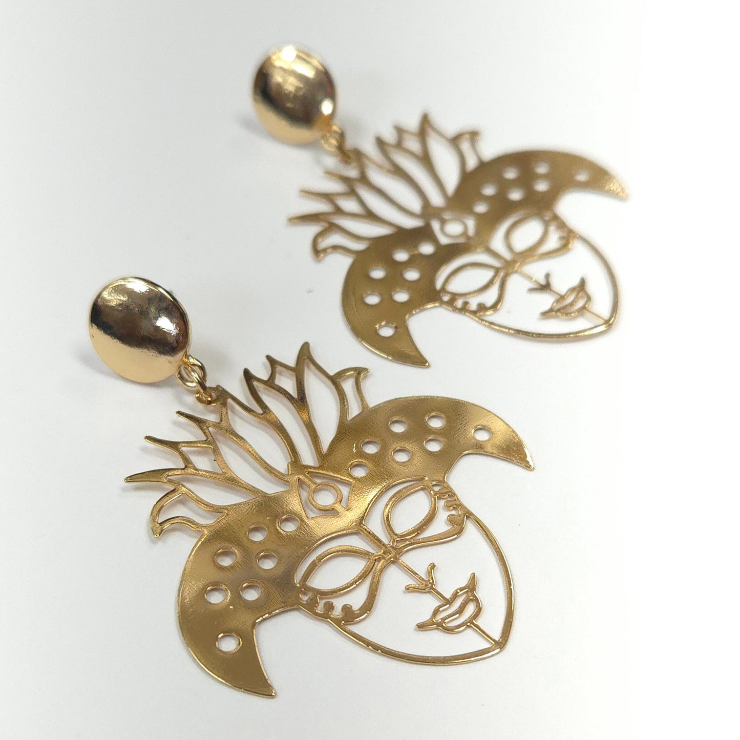 Gold earrings with intricate designs on a white background