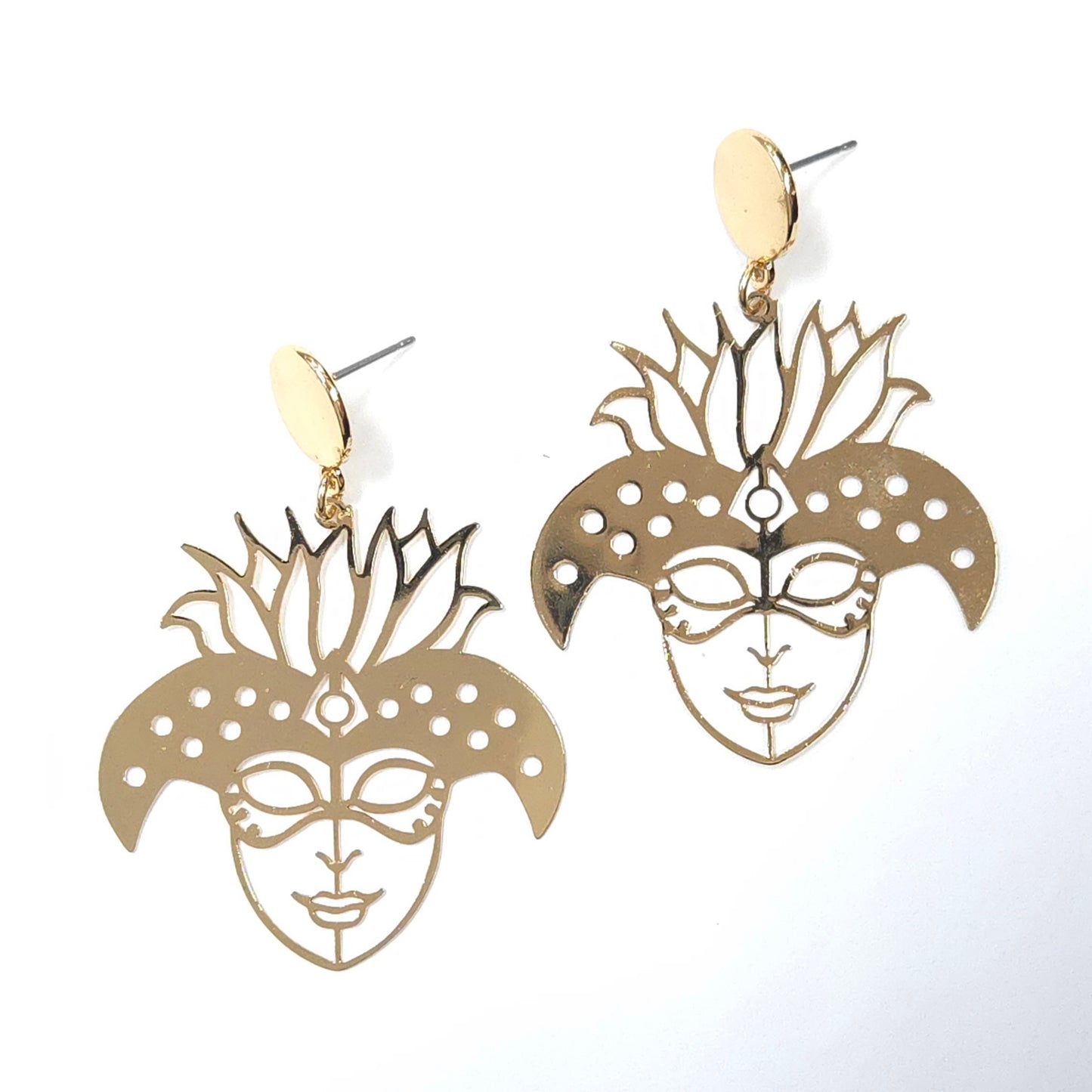 Gold mask-shaped earrings on a white background