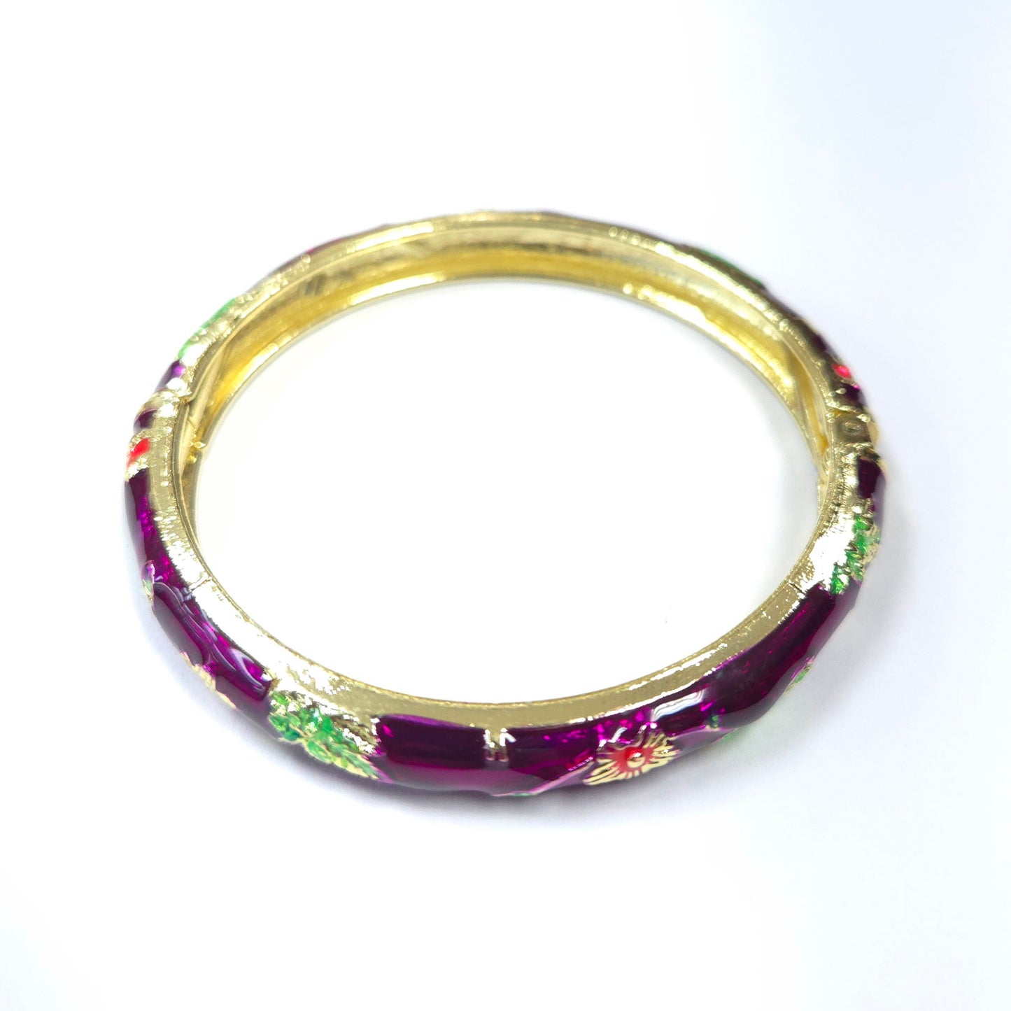 Gold bangle with purple and floral design on a white background
