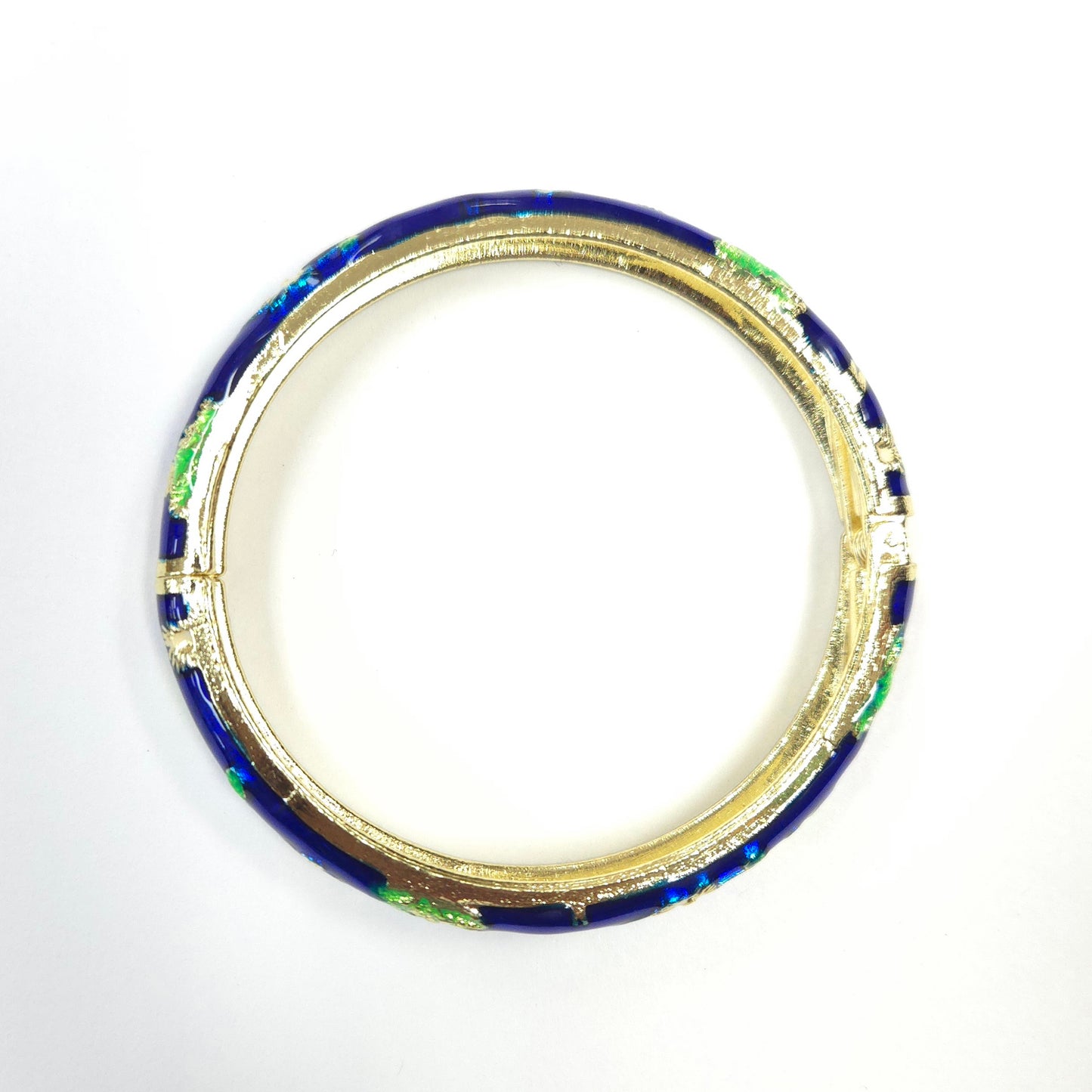Gold ring with blue and green inlay on a white background