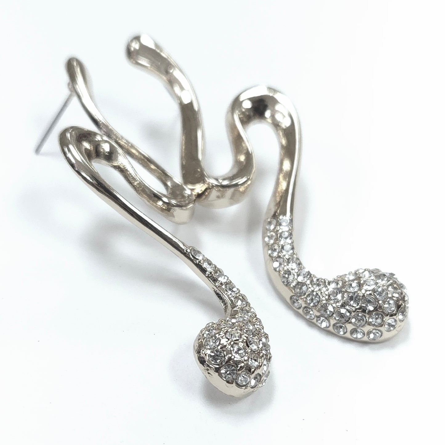 Silver earrings with intricate designs on a white background