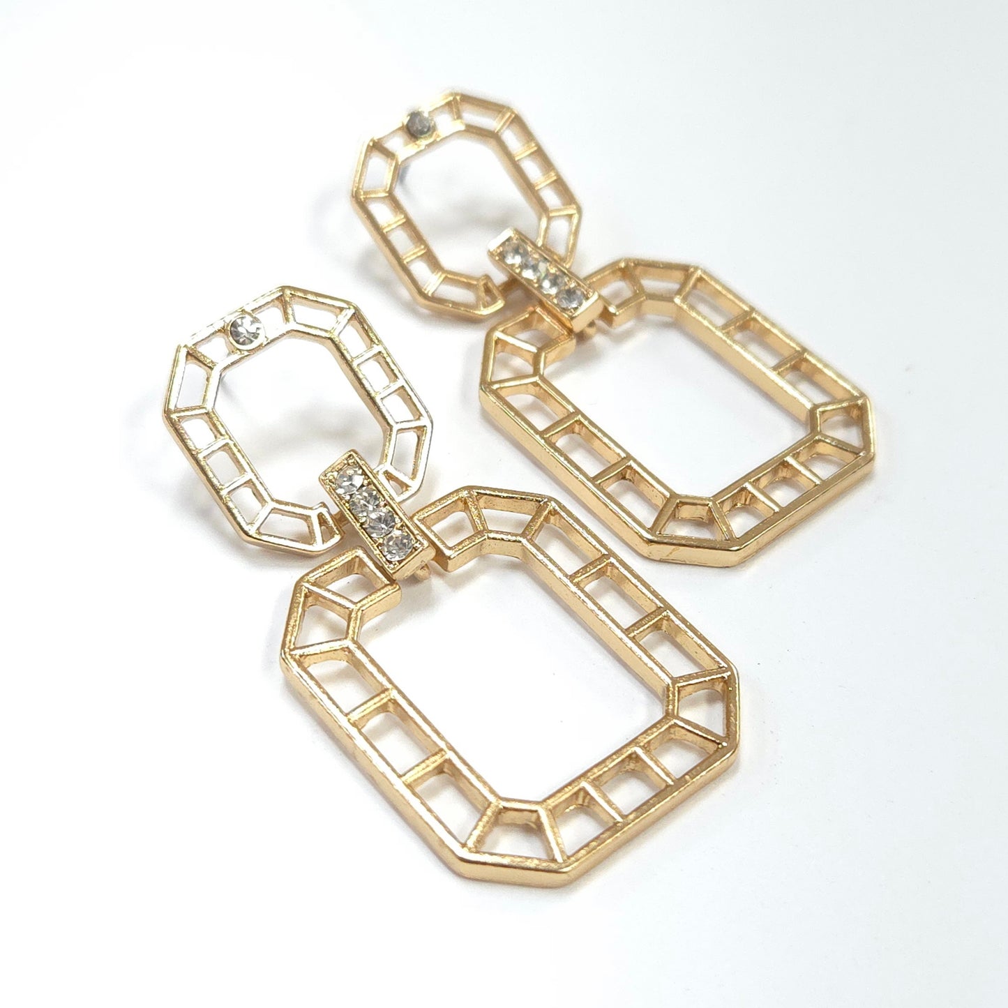 Gold geometric earrings on a white background