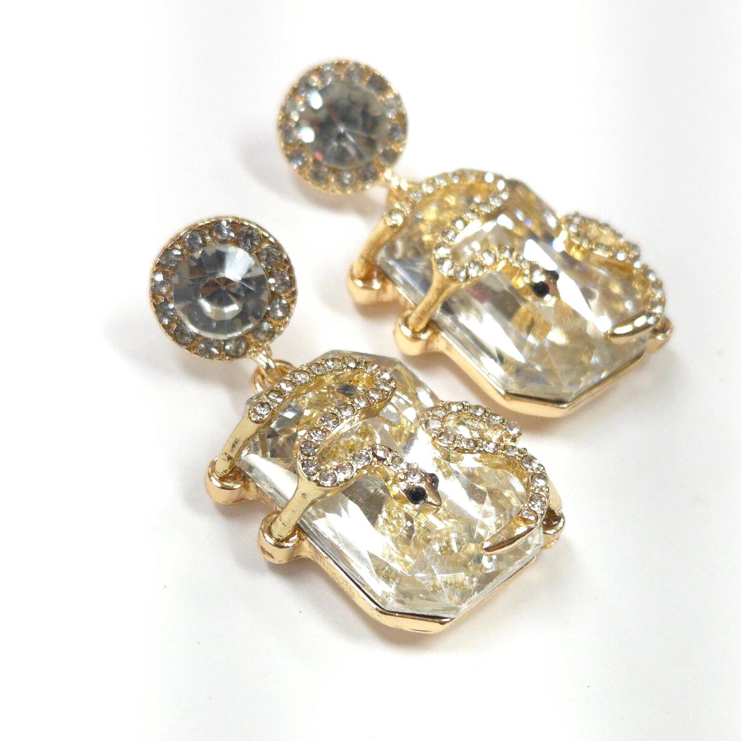Gold and crystal drop earrings on a white background