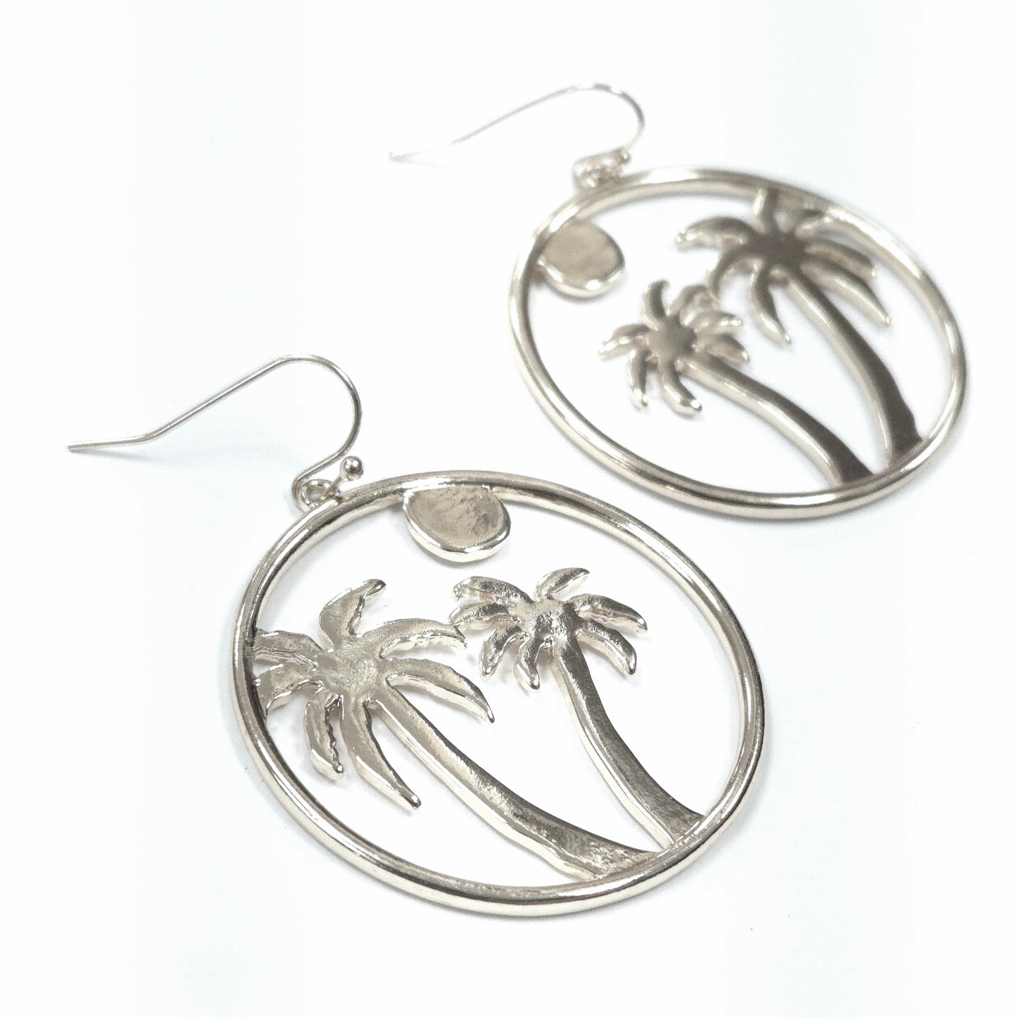Silver hoop earrings with palm tree design on a white background