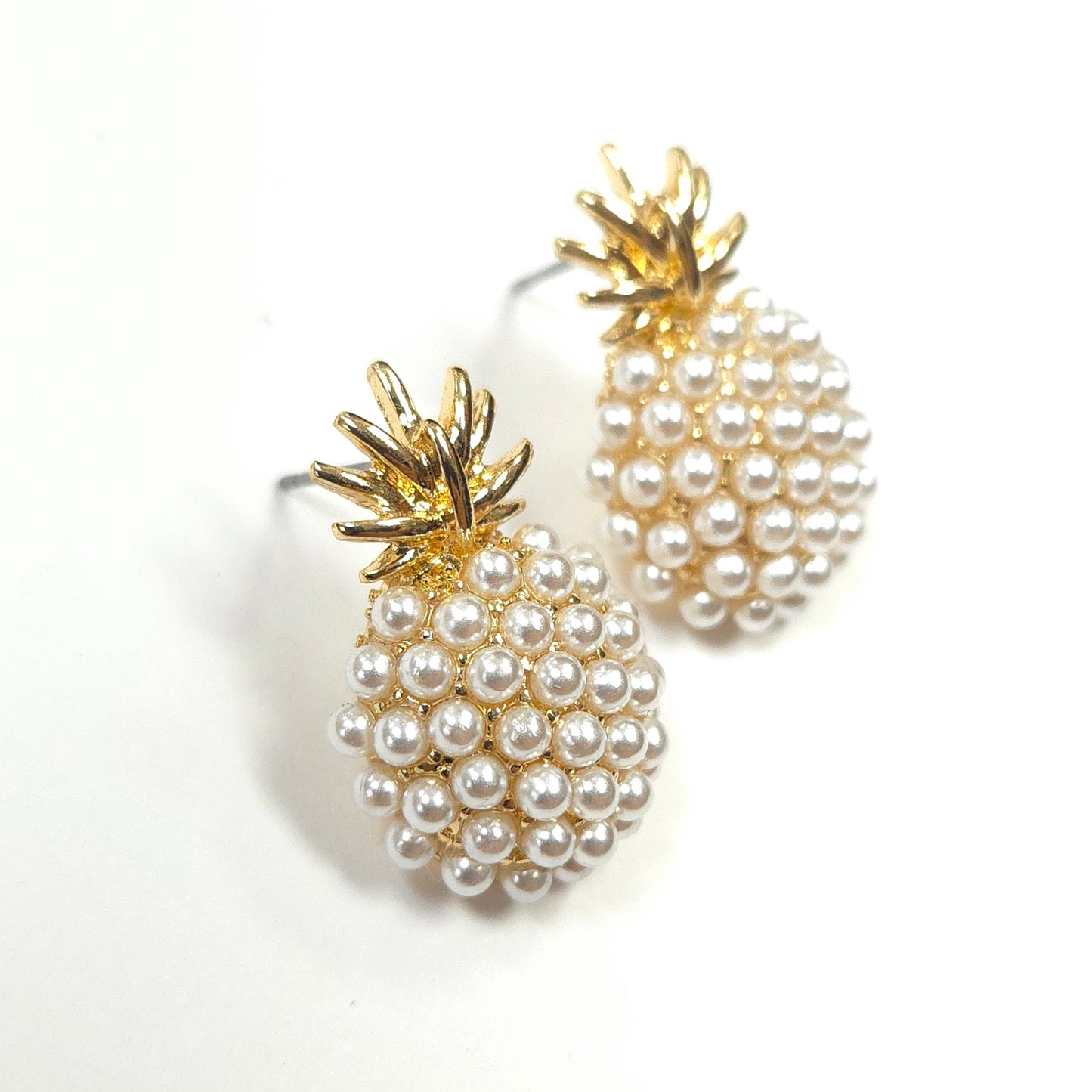 Pineapple-shaped earrings with pearl details on a white background