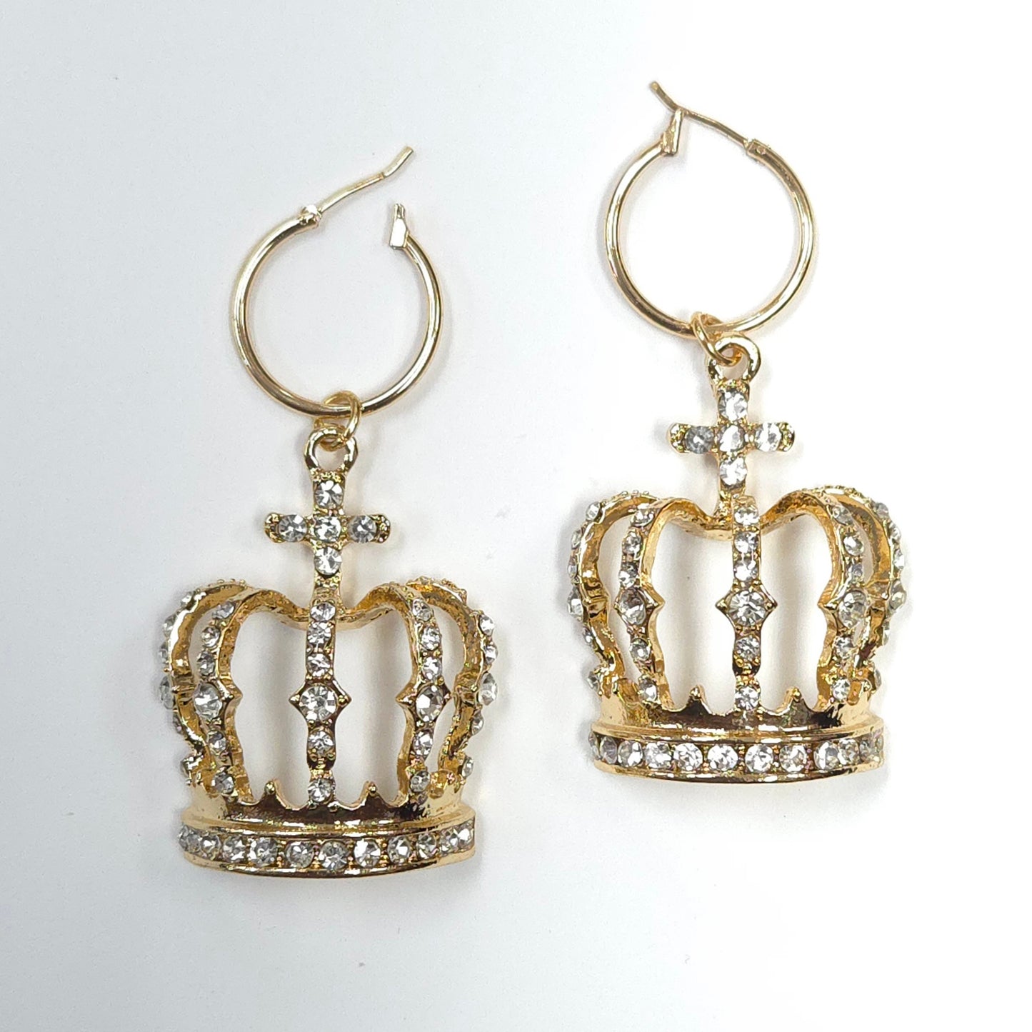 Gold crown-shaped earrings with rhinestones on a white background