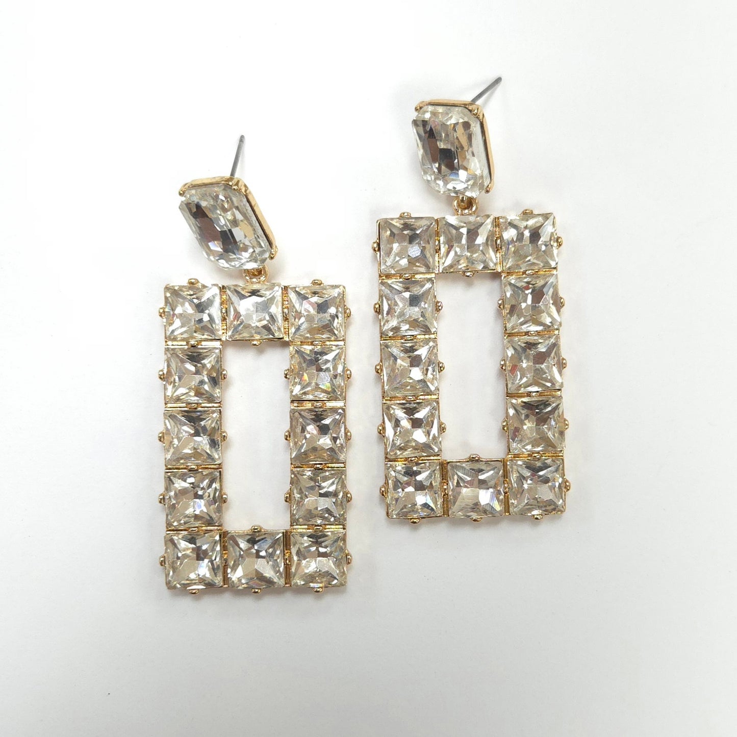 Pair of gold-framed crystal earrings on a white background
