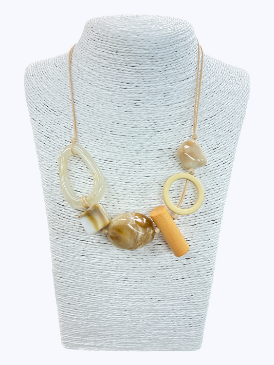 Neutral abstract bead statement necklace with mixed geometric accents and modern asymmetrical cord design on mannequin display