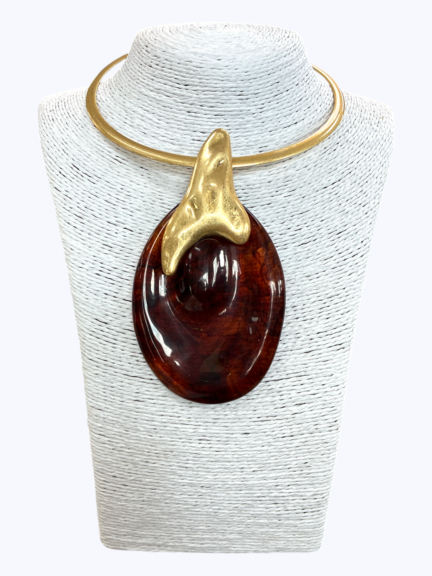 Modern sculptural collar necklace with oversized marbled resin teardrop pendant and metallic abstract accent displayed on mannequin bust.