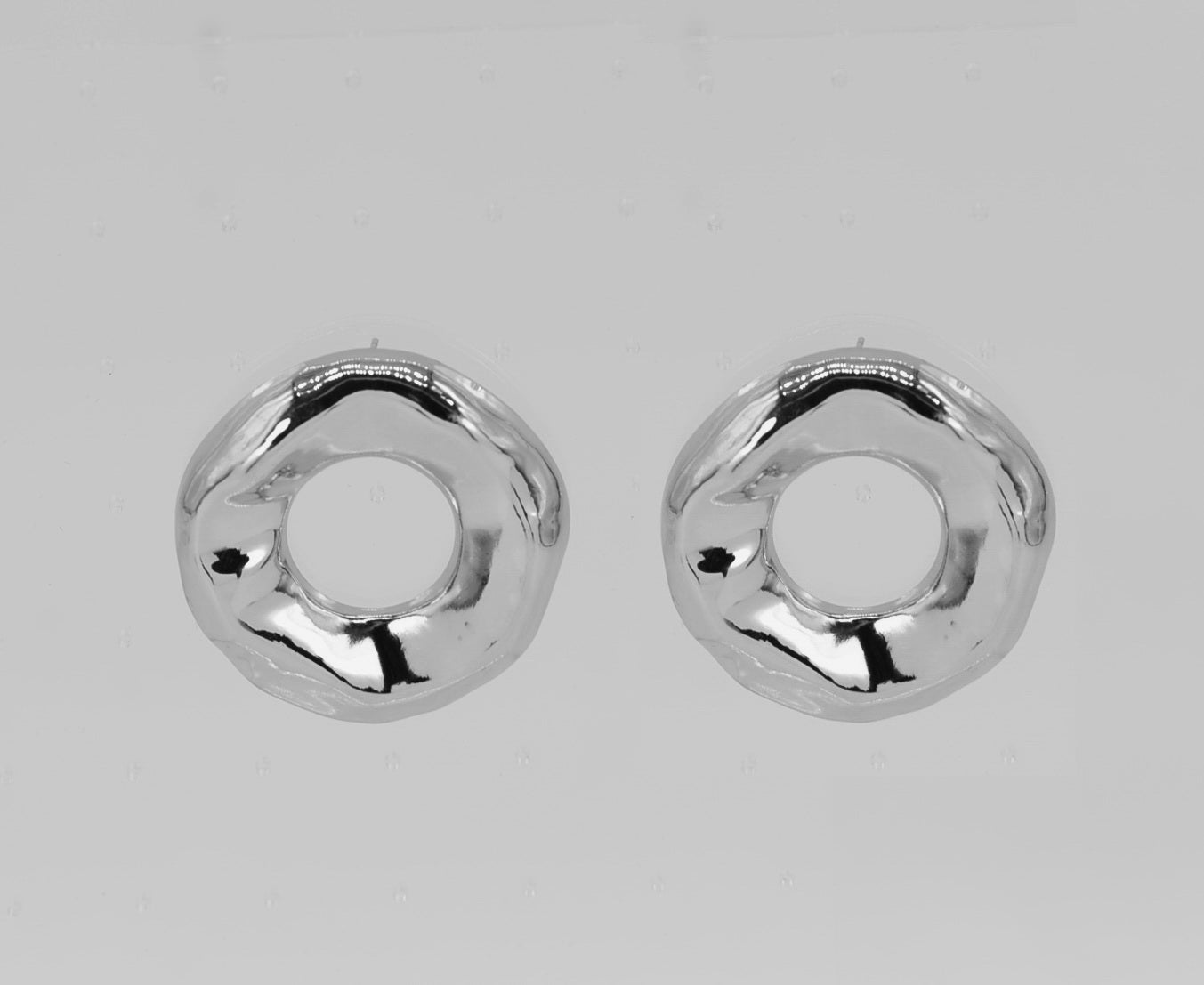 Pair of silver hoop earrings on a light gray background