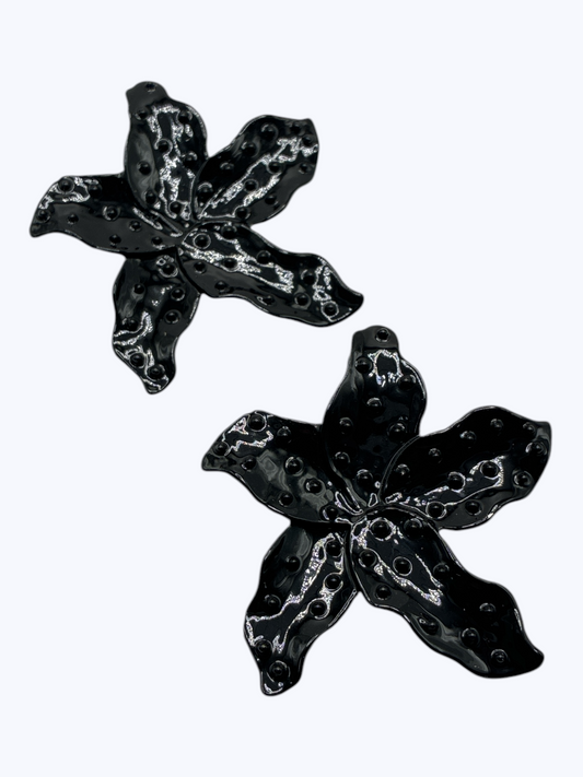 Black floral statement earrings with glossy textured petals and sculpted detailing for a chic modern boutique-inspired style.