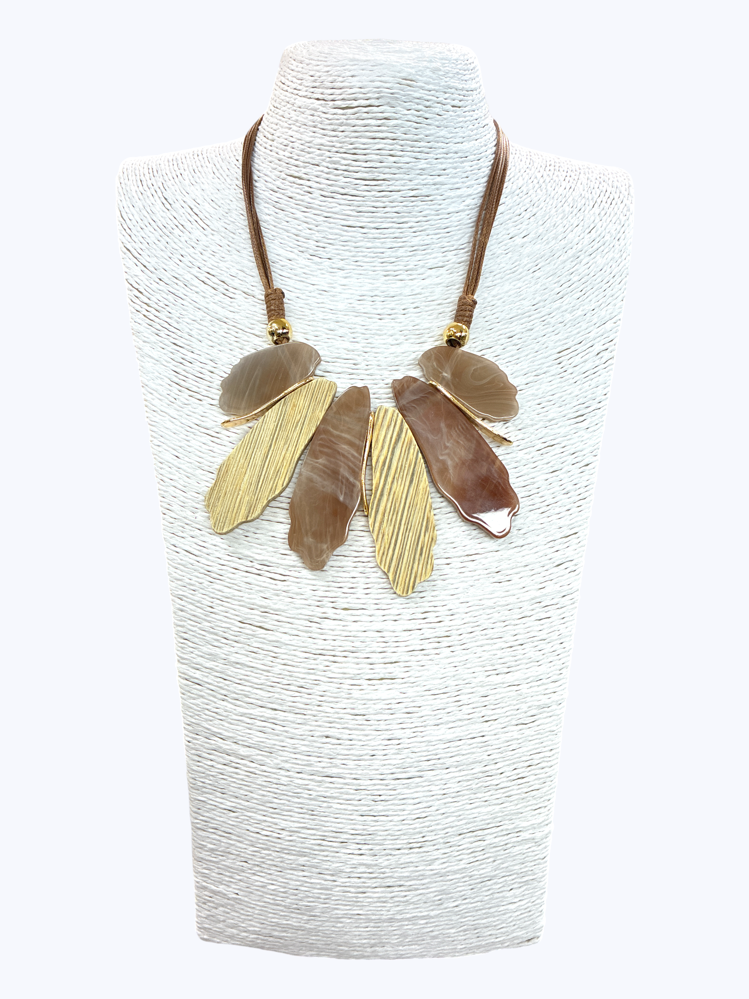 Neutral abstract leaf statement necklace with marbled and textured gold-tone pendants on braided cord for an elegant boutique-inspired style.