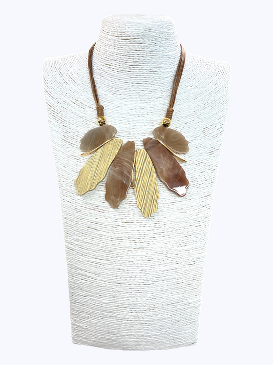 Neutral abstract leaf statement necklace with marbled and textured gold-tone pendants on braided cord for an elegant boutique-inspired style.