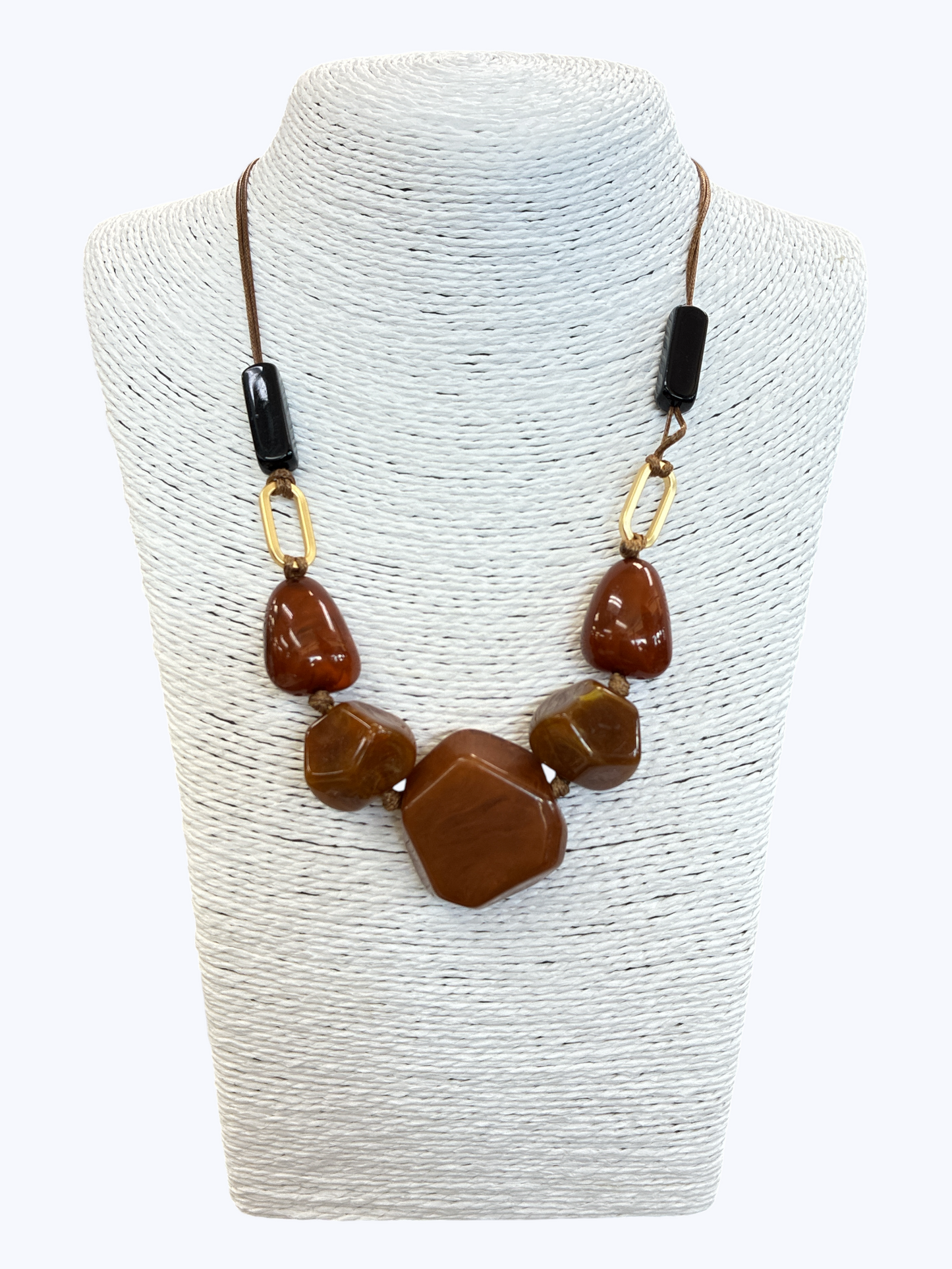 Brown statement bead necklace with glossy marbled resin stones, black cord, and gold-tone accents for a warm contemporary boutique style.