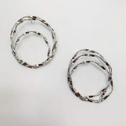 Abstract layered hoop earrings with fluid organic lines and sculptural open-circle design in a modern boutique style.
