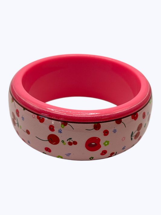 Pink pet bowl with cherry design on a white background