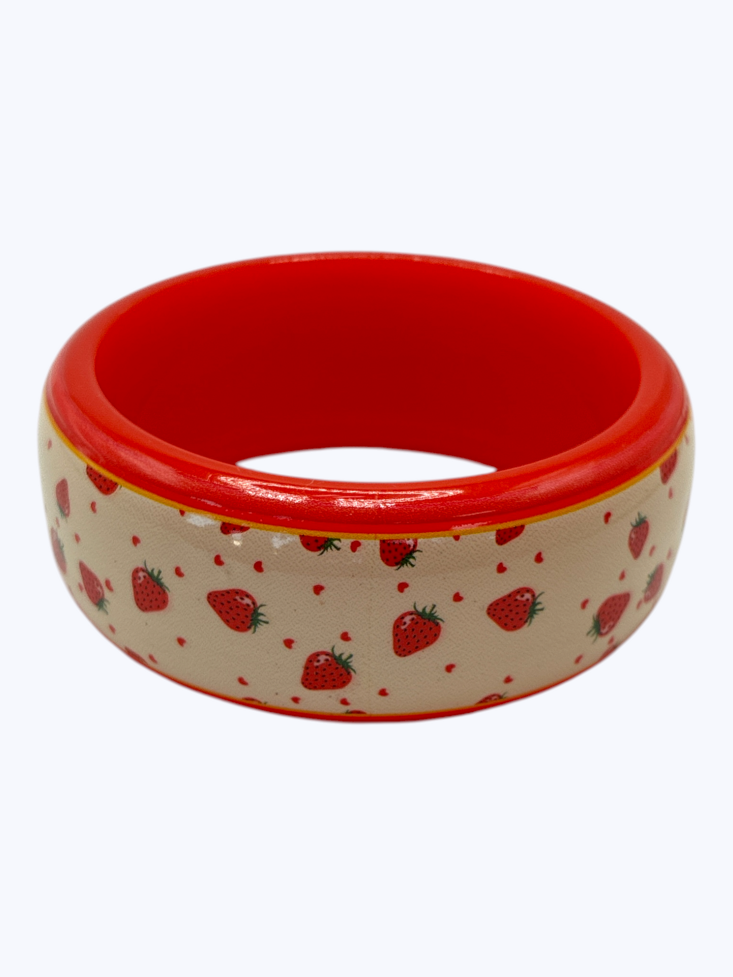 Red and beige bowl with strawberry pattern on a white background