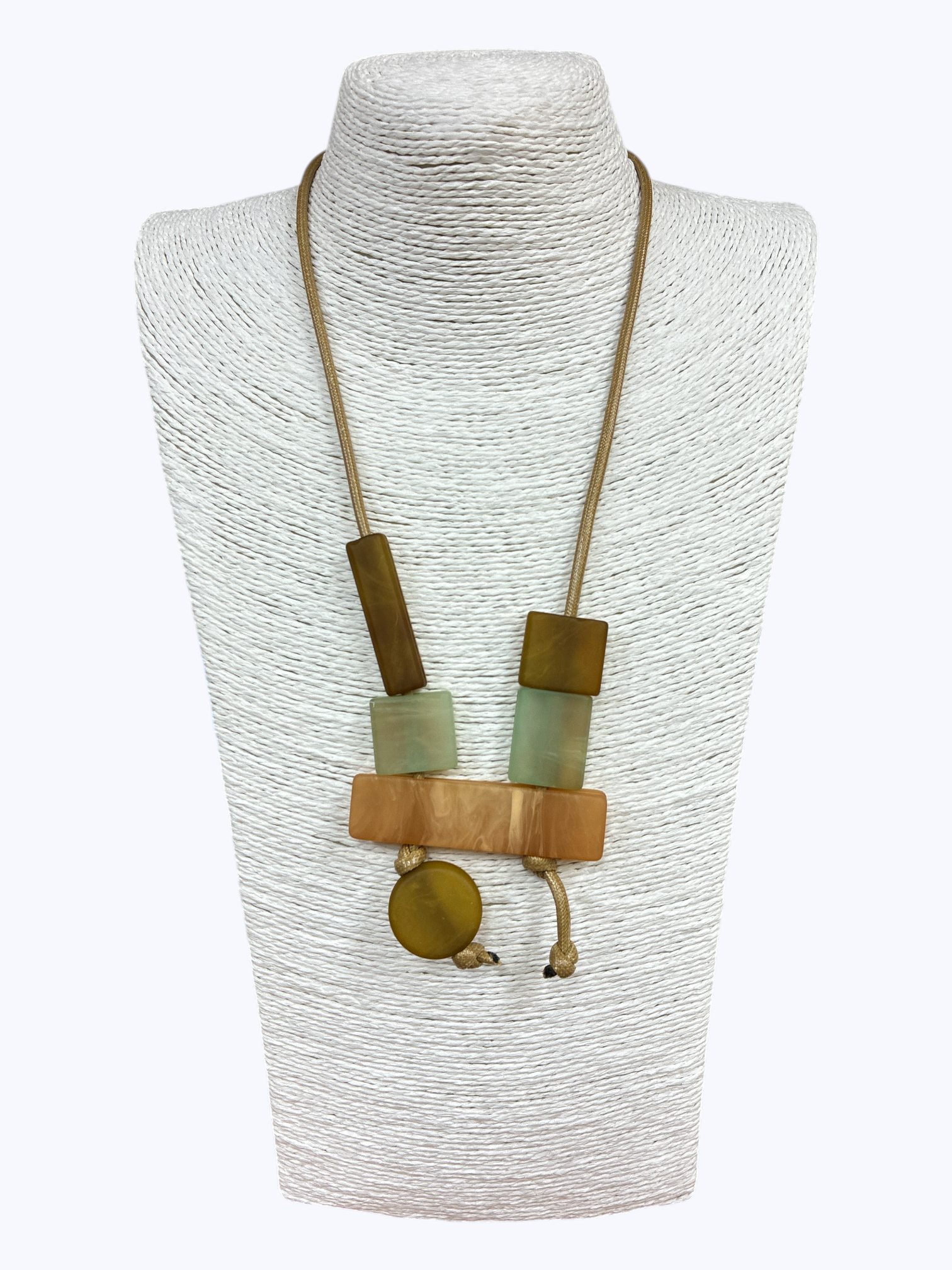 Long pendant necklace with geometric resin and wood-like blocks in a modern abstract arrangement on a cord, displayed on a mannequin bust