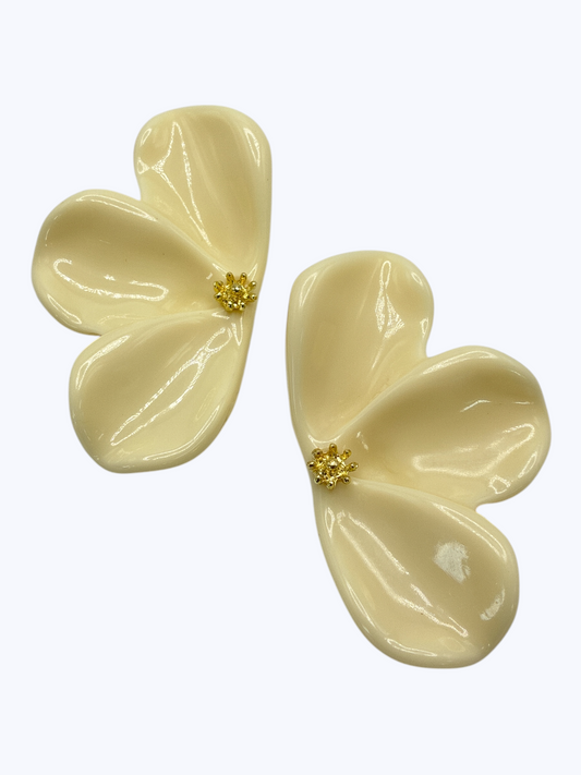 Pair of cream-colored flower-shaped earrings on a white background