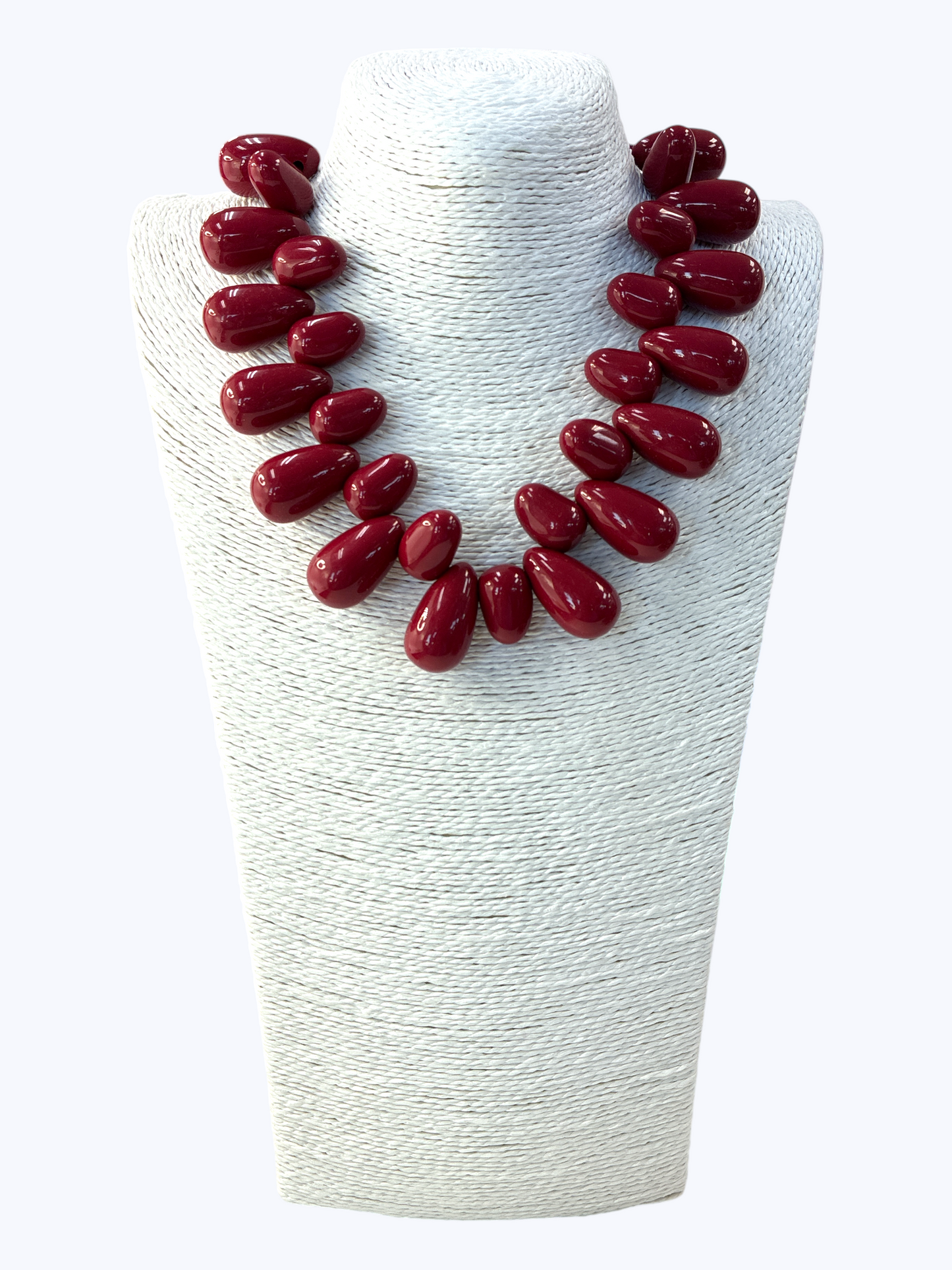 Maroon necklace on a white mannequin bust