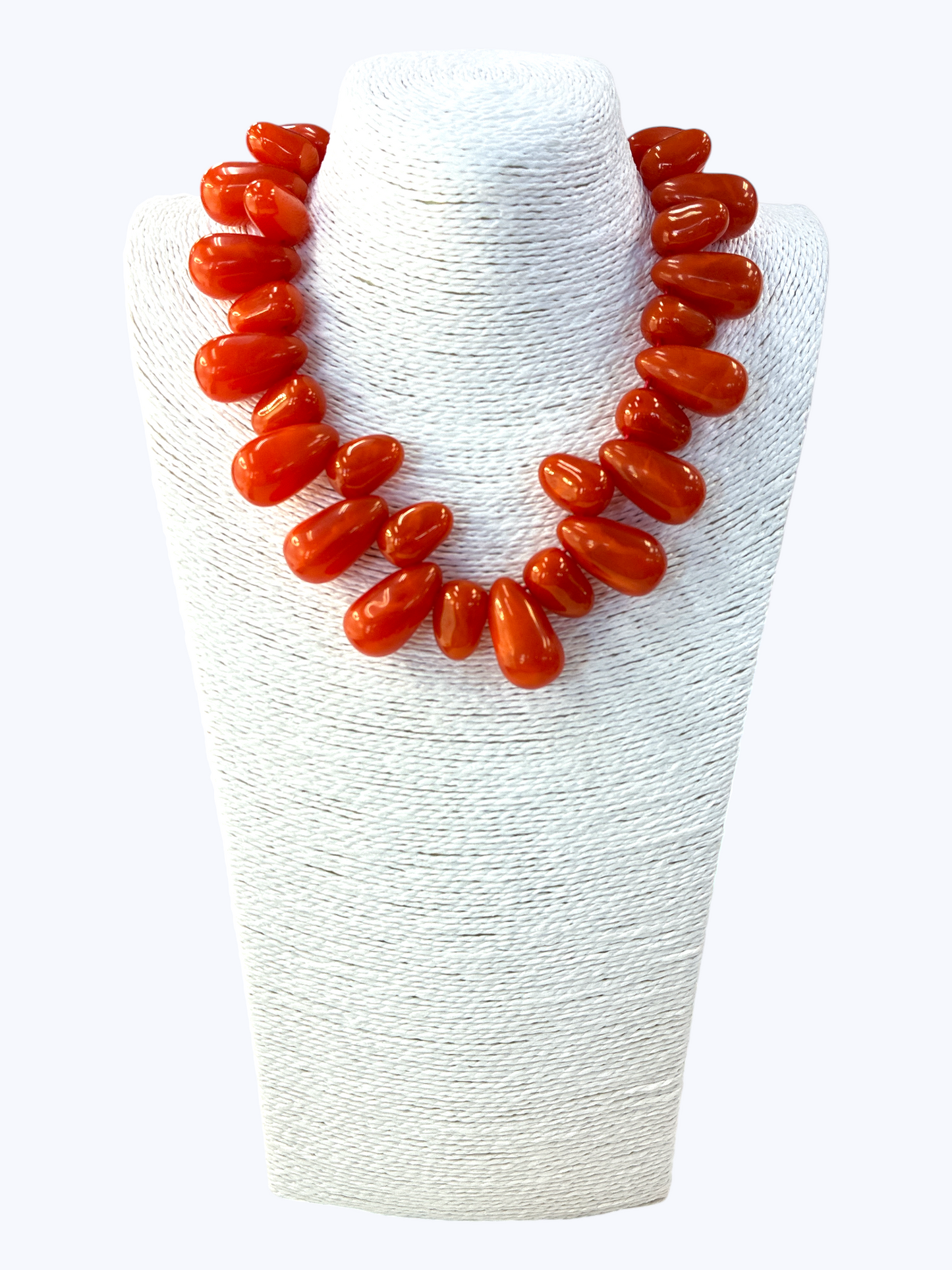 Red beaded necklace on a white stand