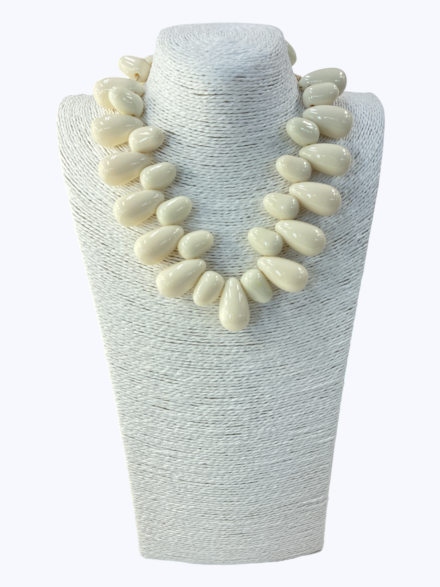Necklace with large white beads on a textured white stand