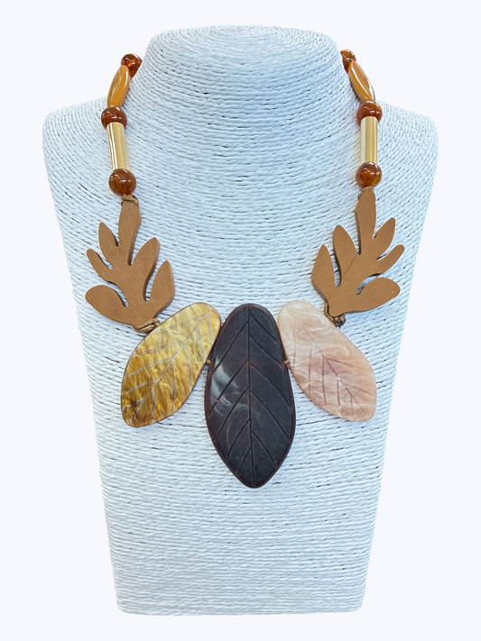 Abstract leaf statement necklace with marbled neutral resin leaves, wooden accents, and earthy bead details for a natural boutique-inspired look.