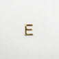 Gold letter 'E' charm on a white background