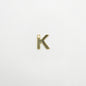 Bronze letter 'K' pendant on a white background