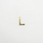 Gold letter 'L' charm on a light gray background