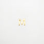 Gold letter 'M' charm on a white background